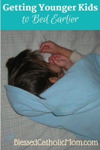 Getting Younger kids to bed earlier can be done. Image of a little boy asleep on his bed, covered in a light blue blanket.