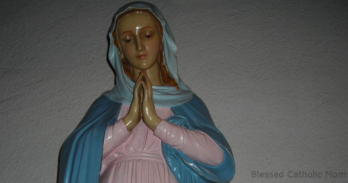 Image of a statue of the Blessed Virgin Mary with her head bowed, eyes closed, and hands together as if in prayer