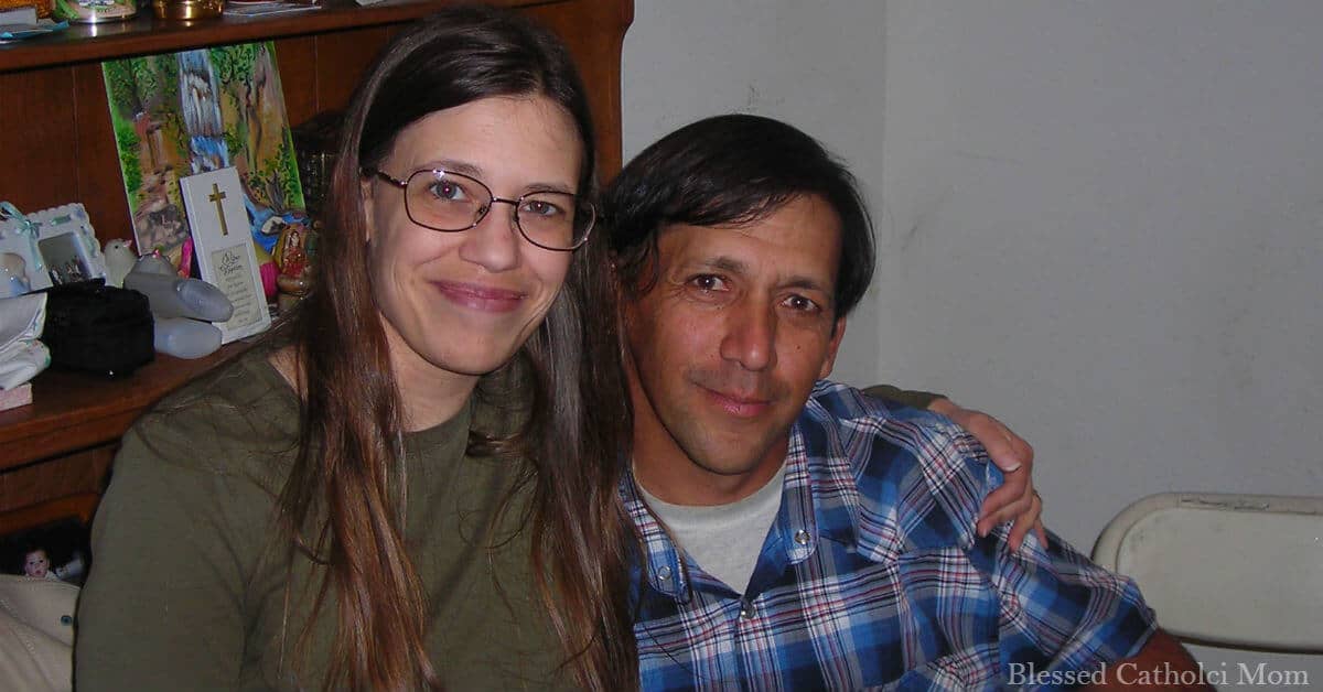 Image of a husband and wife sitting together and smiling at the camera.