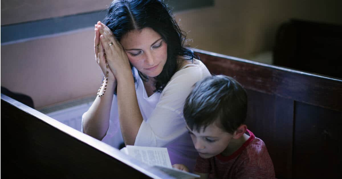 Celebrating Advent can be quite simple: we can chose to limit the secular focus of Christmas and spend some time spiritually preparing our hearts for Jesus. One way to do this is to spend time in prayer at church in front of the Blessed Sacrament. Image of a mother and child praying in church.