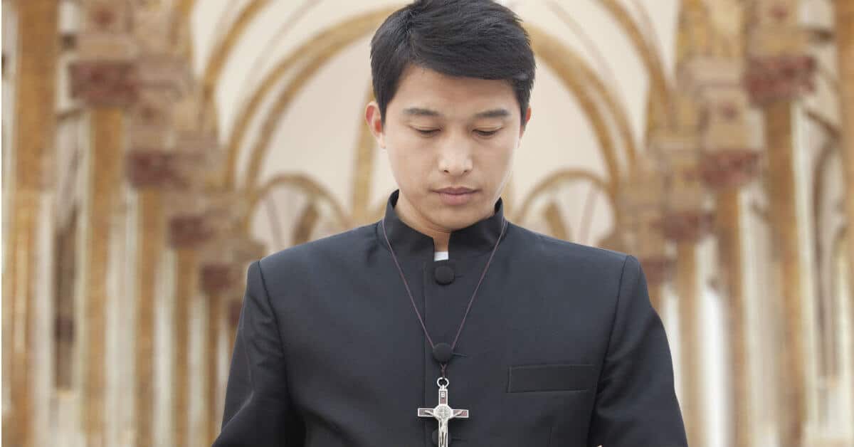 Image of a priest wearing a crucifix and wearing all black.