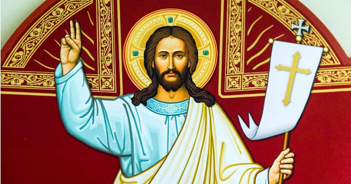 Image of an icon of Jesus holding two fingers up on His right hand and holding a white banner with a golden cross in his left hand.