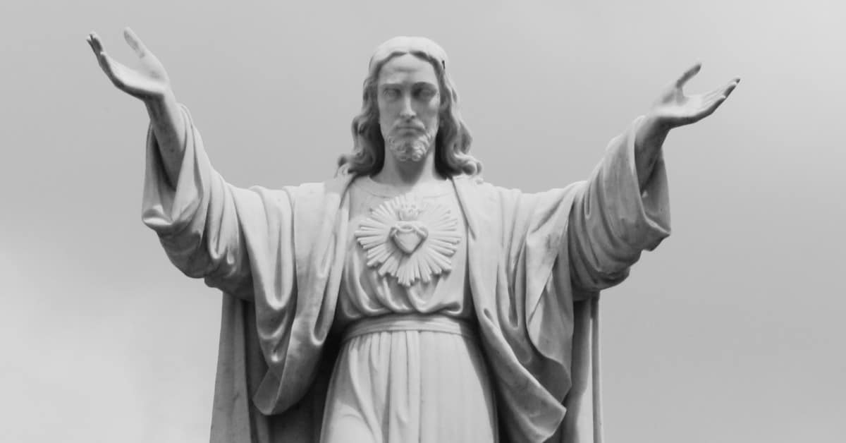 Image of an outdoor statue of Jesus with His Sacred Heart. His arms are outstretched.