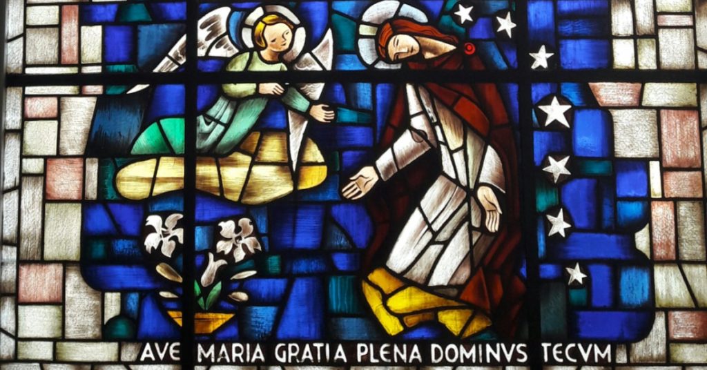 Image of a stained glass window of the Annunciation: the Archangel Gabriel coming to ask Mary to be the Mother of the Christ.