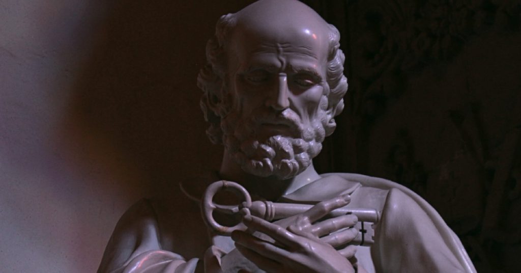 Image of the head and chest of a statue of Saint Peter, the first Pope of the Catholic Church, holding the key to the kingdom of God.