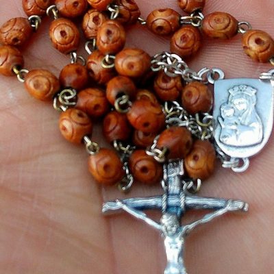 Image of an open hand holding a Rosary.