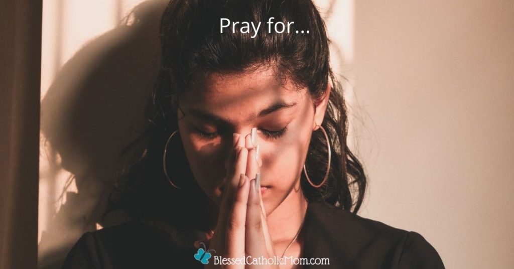Image of a young woman with her hands folded in prayer in front of her face, hed bowed slightly, and eyes closed. The words Pray for... are at the top of the image and the logo for Blessed Catholic Mom is at the bottom.