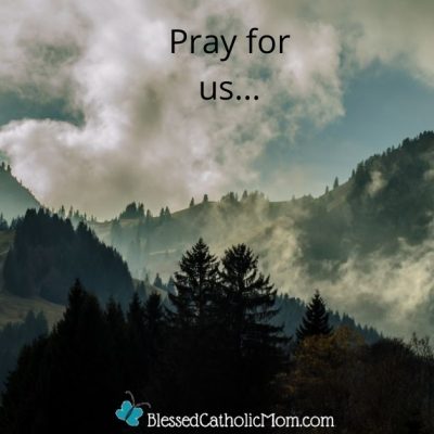Image of mountains wiht pine trees on them and white clouds above them. The words Pray for us... are at the top of the image and the logo for Blessed Catholic mom dot com is at the bottom.