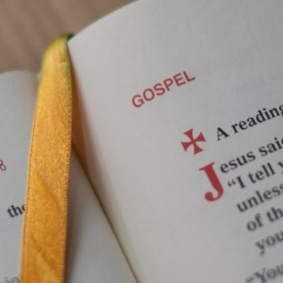 Image of a closeup of an open Bible with a yellow ribbon bookmark.