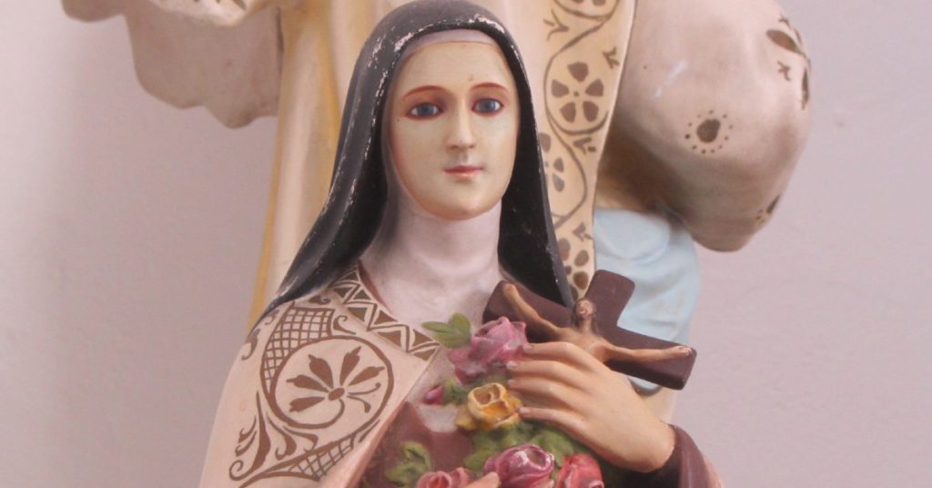 Image of a statue of St. Therese the Little Flower holding a crucifix and roses.