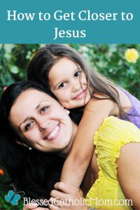 Image of a woman with a yellow shirt smiling at the camera as she holds the arm of a girl who is on her back. The words How to Get Closer to Jesus are at the top of them image and the logo for Blessed Catholic Mom is below.