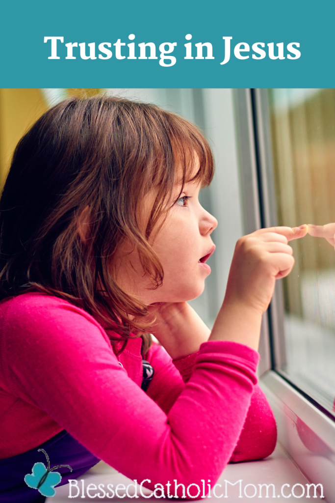 Image of a little girl looking through a window and touching the glass with one pointed finger. Trusting in Jesus are the words above the image and the logo for Blessed Catholic Mom is below.