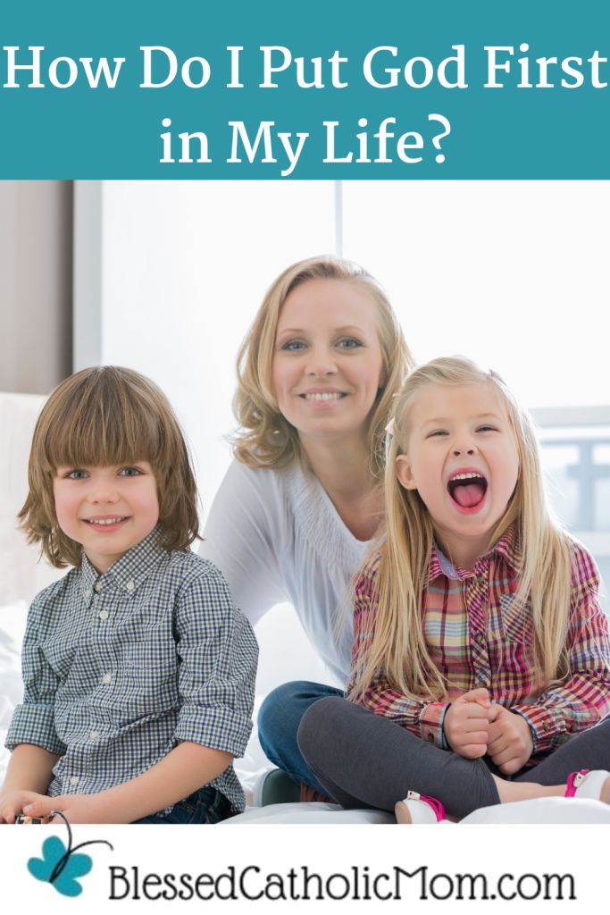How Do I Put God First in My Life? is the title above an image of a woman sitting behind her young son and daughter as they all smile at the camera. The logo for Blessed Catholic Mom is below the image.